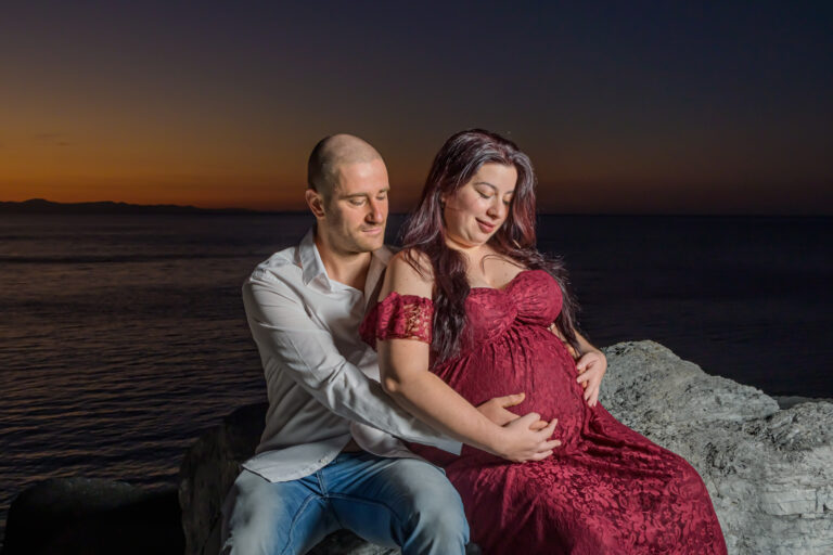 Ragazza incinta e padre che la abbraccia da dietro mentre guardano il pancione - scatto di Ivan D'Amico Fotografo