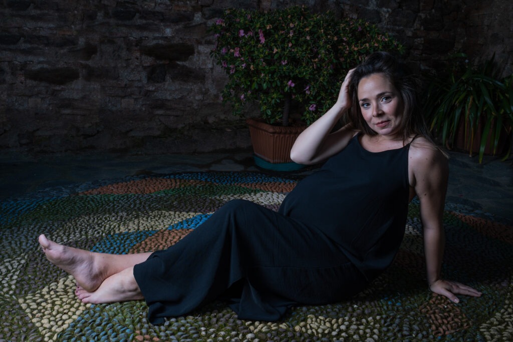 Donna incinta si accarezza i capelli mentre sorride - scatto di Ivan D'Amico Fotografo